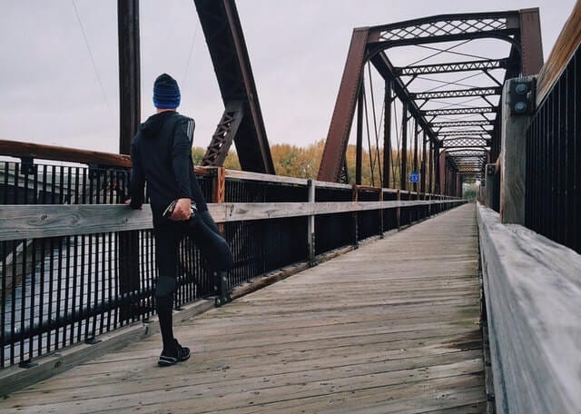 Runner wearing black clothes on the bridge