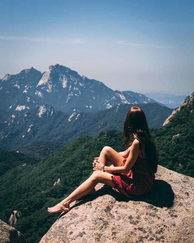 Girl sitting on a mountain
