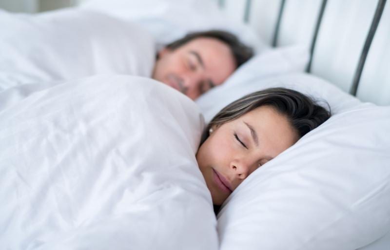 man and woman resting on waterbed