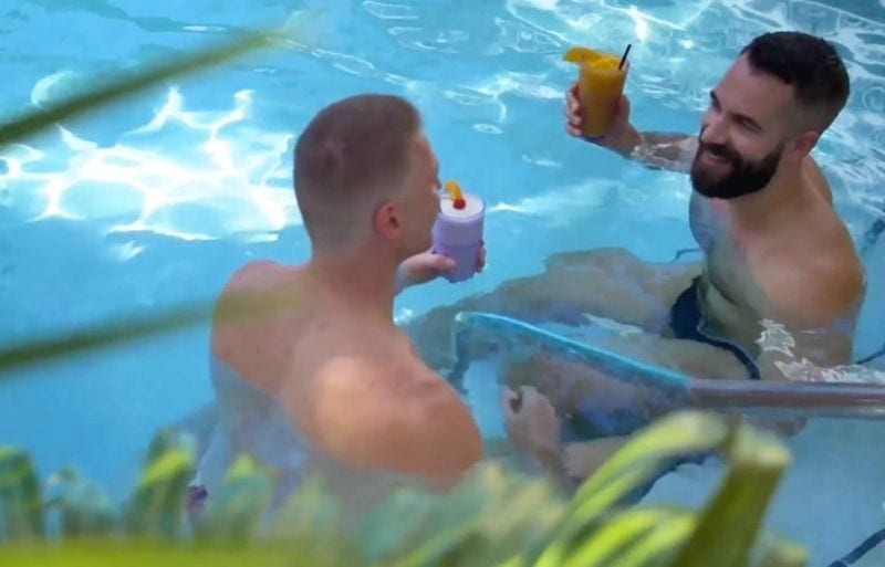 2 guys drinking in an outdoor pool