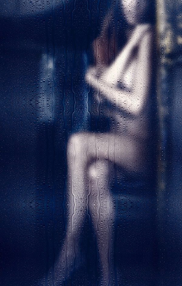 Woman behind wet shower door